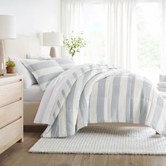 a white and blue striped comforter on a bed