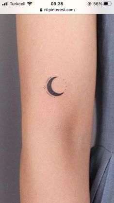 a woman's arm with a small crescent tattoo on the left side of her arm