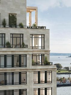 an apartment building with balconies overlooking the water and boats in the bay area