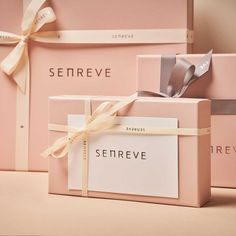 three pink boxes with ribbons tied around them and the words serreve on one