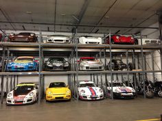 there are many cars on the shelves in this garage, all lined up and ready to be driven