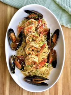 pasta with shrimp and mussels in a white bowl