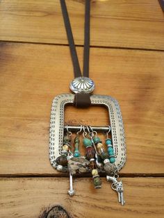 a wooden table topped with a metal container filled with beads and charms