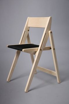 a wooden folding chair with black fabric seat pad on the back and side, against a gray background