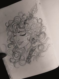 a drawing of a woman's face with curly hair and eyeliners on top of a piece of paper