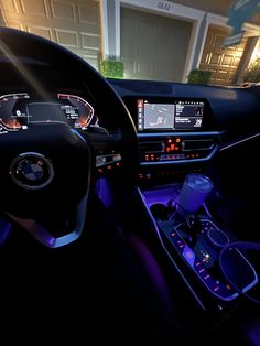 the interior of a modern car is lit up with blue lights and features electronic controls