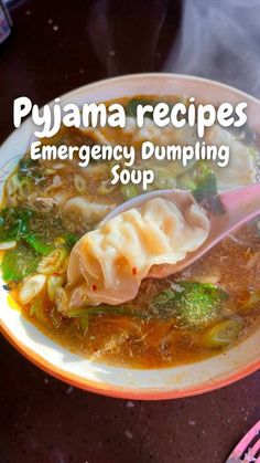 a bowl of dumpling soup with broccoli and noodles in it on a plate