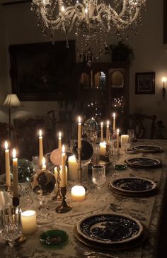 a dining room table is set with candles and plates