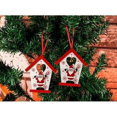 two christmas birdhouses hanging from a tree