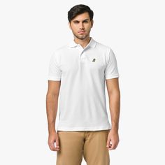 A man standing, wearing a white polo shirt with a small golden embroidered logo on the chest, paired with beige pants. Polo Classic, Office Attire, Cotton Polo, Mens Crew Neck, Caps For Women, Black Border, Luxury Fabrics, Style Icon, Pima Cotton