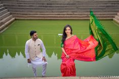 a man standing next to a woman in a pink and green sari