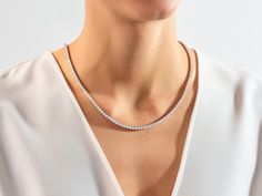 The Lab Diamond Tennis Necklace is a sophisticated and elegant piece of jewelry featuring lab-grown diamonds with a diameter of 3.00 millimeters. The necklace consists of a continuous string of these sparkling diamonds set in a delicate and classic tennis style, creating a timeless and glamorous accessory. Features Made to Order Gold Kt: 14K Solid Gold or 18K Solid Gold Gold Colors: Rose Gold, Yellow Gold, White Gold Gemstone: Lab Diamond Stone Cut: Round Stone Size: 3.00 mm Wide: 3.50 mm Color Elegant White Gold Tennis Necklace With Round Cut, Minimalist Cubic Zirconia Tennis Necklace For Formal Occasions, Formal Single Strand Round Cut Diamond Necklace, Elegant Tennis Necklace With Brilliant Cut, Elegant Round Tennis Necklace With Brilliant Cut, Wedding Tennis Necklace With Brilliant Round Cut, Minimalist Diamond Tennis Necklace For Anniversary, Brilliant Cut Tennis Necklace For Wedding, Formal Minimalist Cubic Zirconia Tennis Necklace