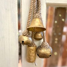 three bells hanging from a white door