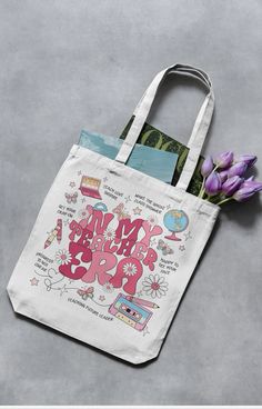 This cute teacher’s tote bag makes a great gift for any teacher, student teacher or anyone in the education world. Adorned with all things “teacher” and the print “In My Teacher Era” Back To School Gift Canvas Tote Bag, Back To School Canvas Bag With Letter Print, Letter Print Bag For End Of School Year Gift, Letter Print Bag As End Of School Year Gift, End Of School Year Gift Bag With Letter Print, Letter Print Bags As End Of School Year Gift, Back To School Everyday Canvas Bag With Letter Print, Mother's Day Canvas Gift Bag For School, Back To School Canvas Bag Gift