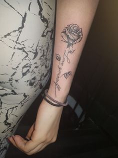 a woman with a rose tattoo on her arm