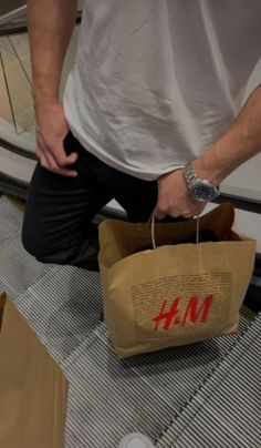 a man is standing on an escalator holding a bag