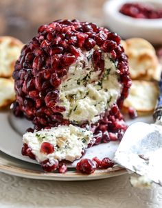 a piece of cheese covered in cranberry sauce on a plate with crackers