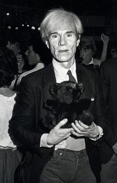 an old man holding a teddy bear in his hands