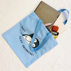 This eco-friendly bag is both adorable and motivational, reminding you to keep swimming. With its reusable design and convenient interior pocket, it's the perfect choice for carrying a laptop, large agenda, or small belongings. Eco-friendly meets fashion in the Just Keep Swimming Eco Bag. Dimensions: 15" x 15" for the bag, shoulder straps Ethically sourced, reusable, recyclable, no plastic packaging Designed by Young in house, crafted in China Practical Reusable School Bag, Recyclable Everyday Bags For Back To School, Eco-friendly Recyclable School Bags, Eco-friendly Bags For Daily Use And Back To School, Just Keep Swimming, Jewelry Roll, Keep Swimming, Eco Friendly Bags, Hair Setting