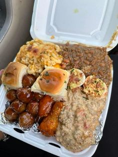 a plastic container filled with different types of food on top of tin foil covered in sauce