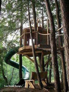 a tree house with a slide in the woods