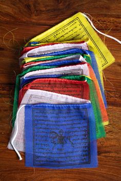 a bunch of colorful bags sitting on top of a wooden table