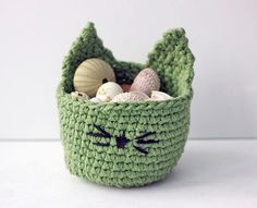 a green crocheted basket filled with lots of different types of eggs and shells