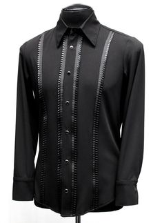 A classic cut, formal shirt for any occasion. A comfortable black rayon shirt with an elegant, tapered fit. Pleated black ribbon trim down the front adds a subtle, understated flair. Fastens in front and at cuffs with rich black pearl snaps. Smoooth! Comes in sizes Small-3X. Measurements: Small: Chest 38-42" Waist 30-32" Medium: Chest 42-44" Waist 32-38" Large: Chest 44-46" Waist 38-42" XL: Chest 48-50" Waist 42-44" XXL: Chest 50-52"" Waist 44-49" 3X: Chest 54' Waist 49" Black Fitted Formal Shirt, Elegant Black Dress Shirt For Semi-formal Occasions, Classic Fitted Black Shirt, Classic Black Formal Tops, Black Long Sleeve Dress Shirt For Party, Black Fitted Shirt For Semi-formal Occasions, Tailored Black Top For Evening, Classic Black Formal Shirt, Classic Tailored Black Tops