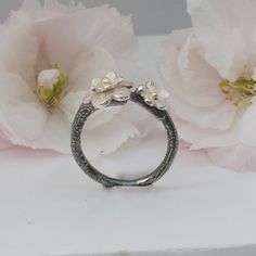 a close up of a ring with flowers in the background