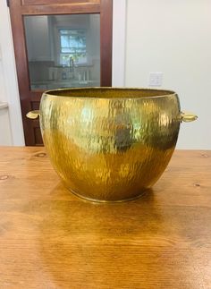 a large metal bowl sitting on top of a wooden table