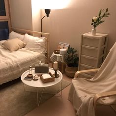 a living room filled with furniture next to a bed and a table in front of a window