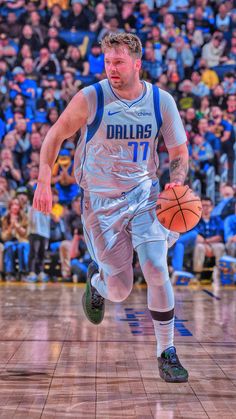 a basketball player running with the ball in his hand and people watching from the stands