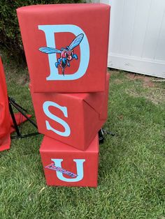 the letters are made out of red blocks with a blue and white bee on them