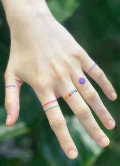 a woman's hand with two different colored rings on her left thumb and the other half of her finger