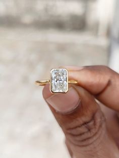 a person holding a ring with a diamond in it