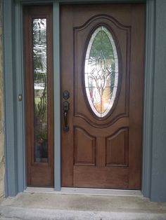 the front door is decorated with stained glass and has a wreath on it's side