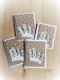 four snowman cards on a wooden table with white polka dots and brown backings