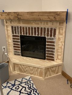 a fireplace is being built in the corner of a room with a rug on the floor