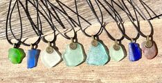 five different colored sea glass pieces hanging from leather cord