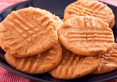 three peanut butter cookies on a black plate