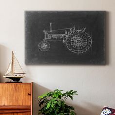 a drawing of a tractor on a chalkboard in a room with a chair and potted plant