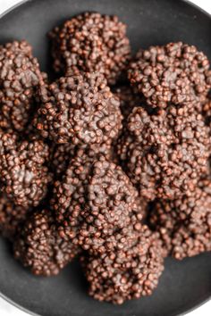 chocolate truffles in a black bowl on a white surface