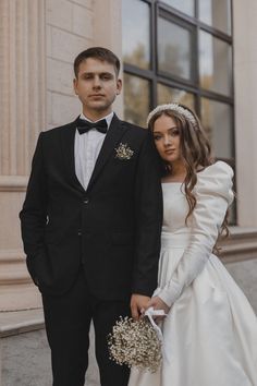 a man and woman in formal wear standing next to each other