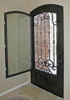 an open door with wrought iron bars on the side and glass panels on the inside