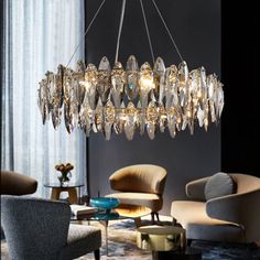 a chandelier hanging from the ceiling in a living room with chairs and tables