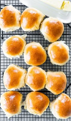 baked rolls on a cooling rack with butter in the background