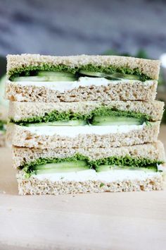 four sandwiches stacked on top of each other with cucumber and cream fillings