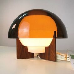 an orange and black lamp sitting on top of a table