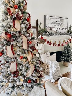 a christmas tree decorated with red, white and gold ornaments is in the corner of a living room