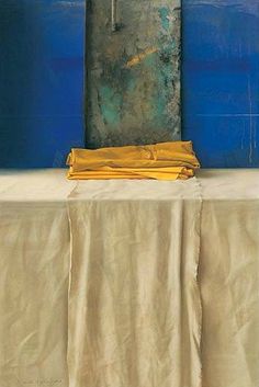 a table with a yellow cloth on it in front of a blue and white wall